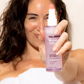 An image of a woman holding up Solawave moisturizing face mist