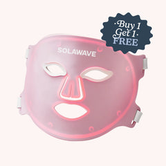 The Solawave Wrinkle Retreat Pro LED Face Mask with red, infrared, deep red, and amber light therapy is shown in pink with cutouts for the eyes, nose, and mouth. A "Buy 1 Get 1 Free" sticker appears on top right. White side straps complete the anti-aging design.