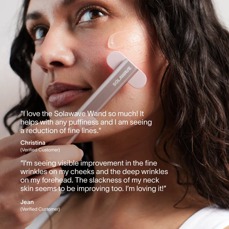 A woman uses the Solawave 4-in-1 Red Light Therapy Wand & Activating Serum Kit on her cheek, while glowing customer reviews about its effect on fine lines, dark spots, puffiness, and skin improvement appear in white text.|| Rose Gold